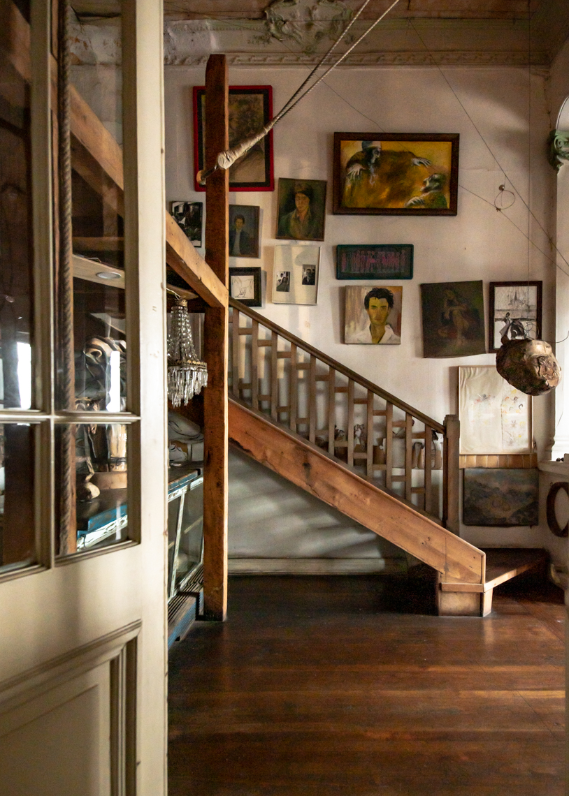 wooden staircase under wall lined with paintings