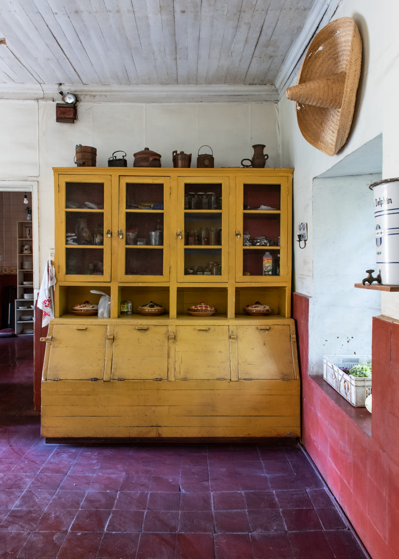 Yellow painted kitchen hutch on red tiles in a chilean hacienda