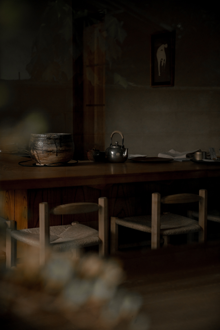 dark kyoto tea house with wooden furniture and silver teapot