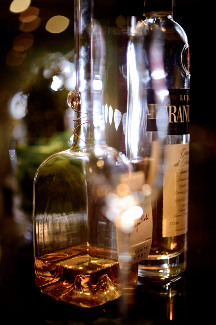 blurry image of glass of scotch with bottle behind it