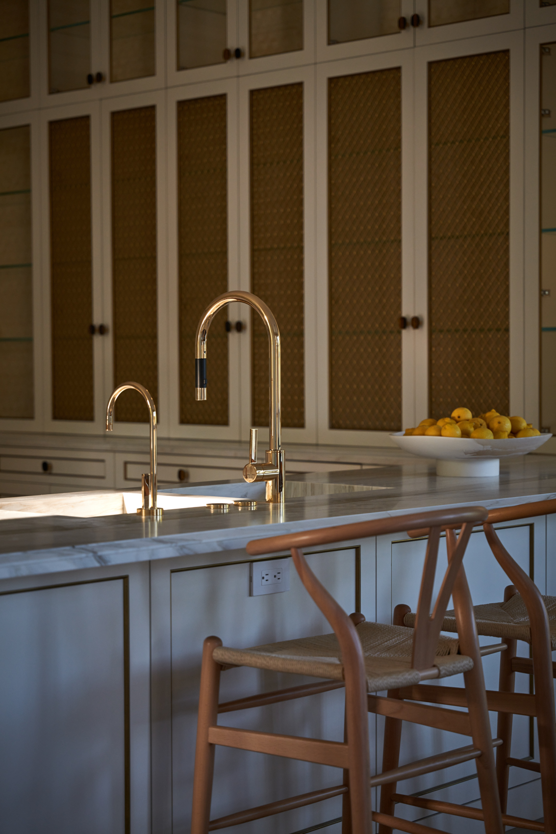 Kitchen sink with gold hardware and marble counters
